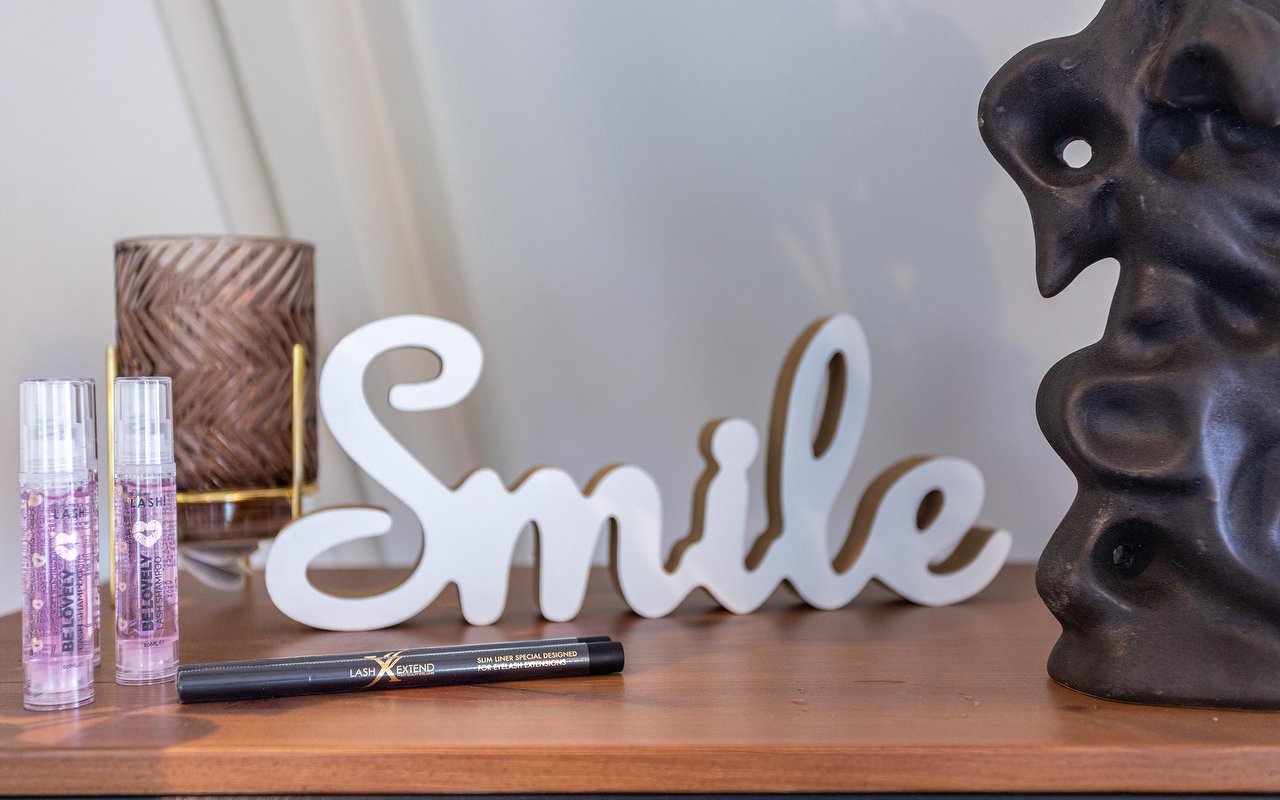 Witte letters Smile naast serumflesjes en een zwart beeldje in de salon