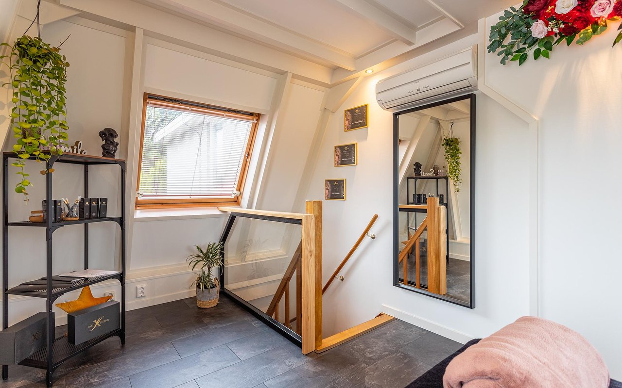 Kast met producten, planten en een spiegel bij de trap